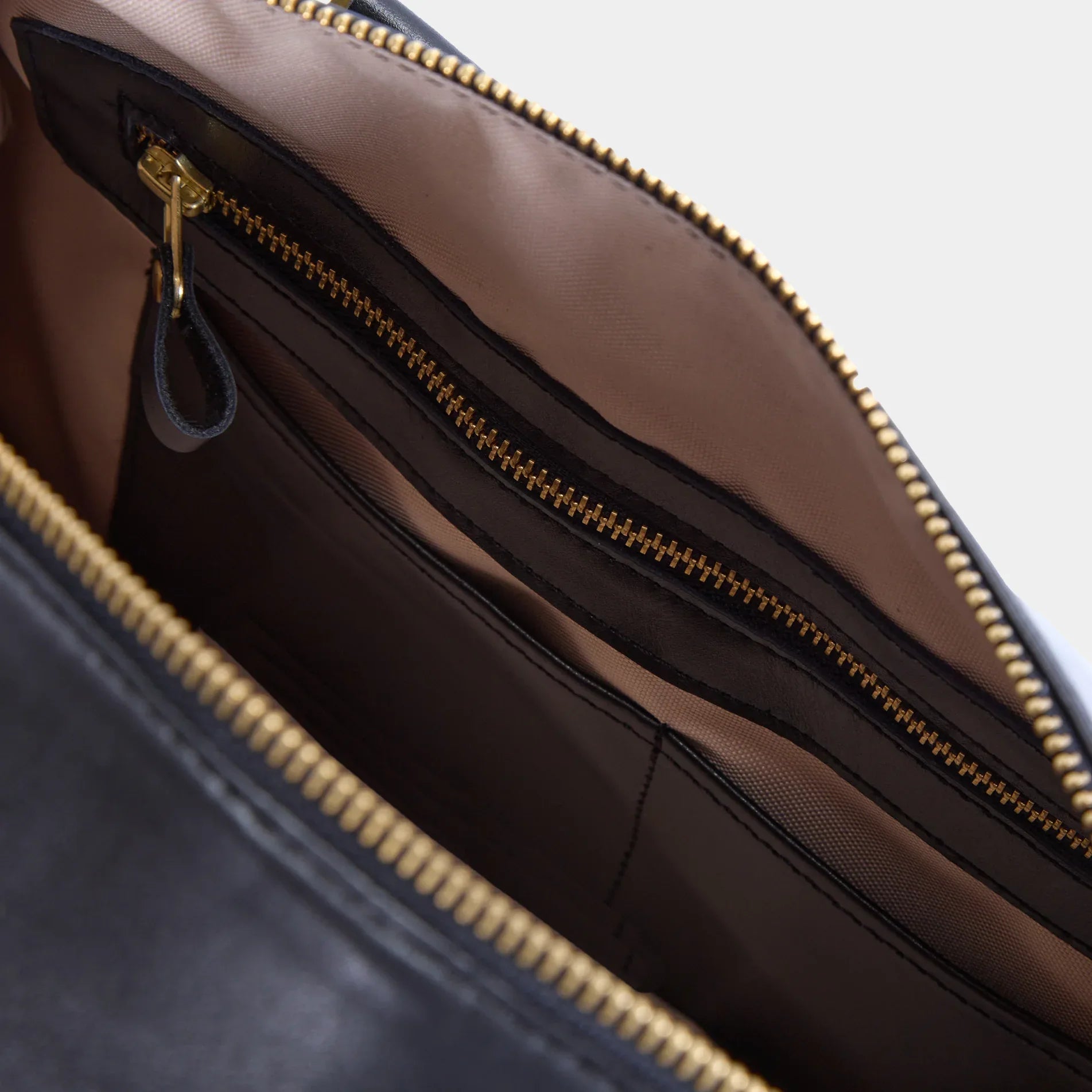 Open Nomad leather weekend bag displaying roomy main compartment with durable lining and internal zip pocket