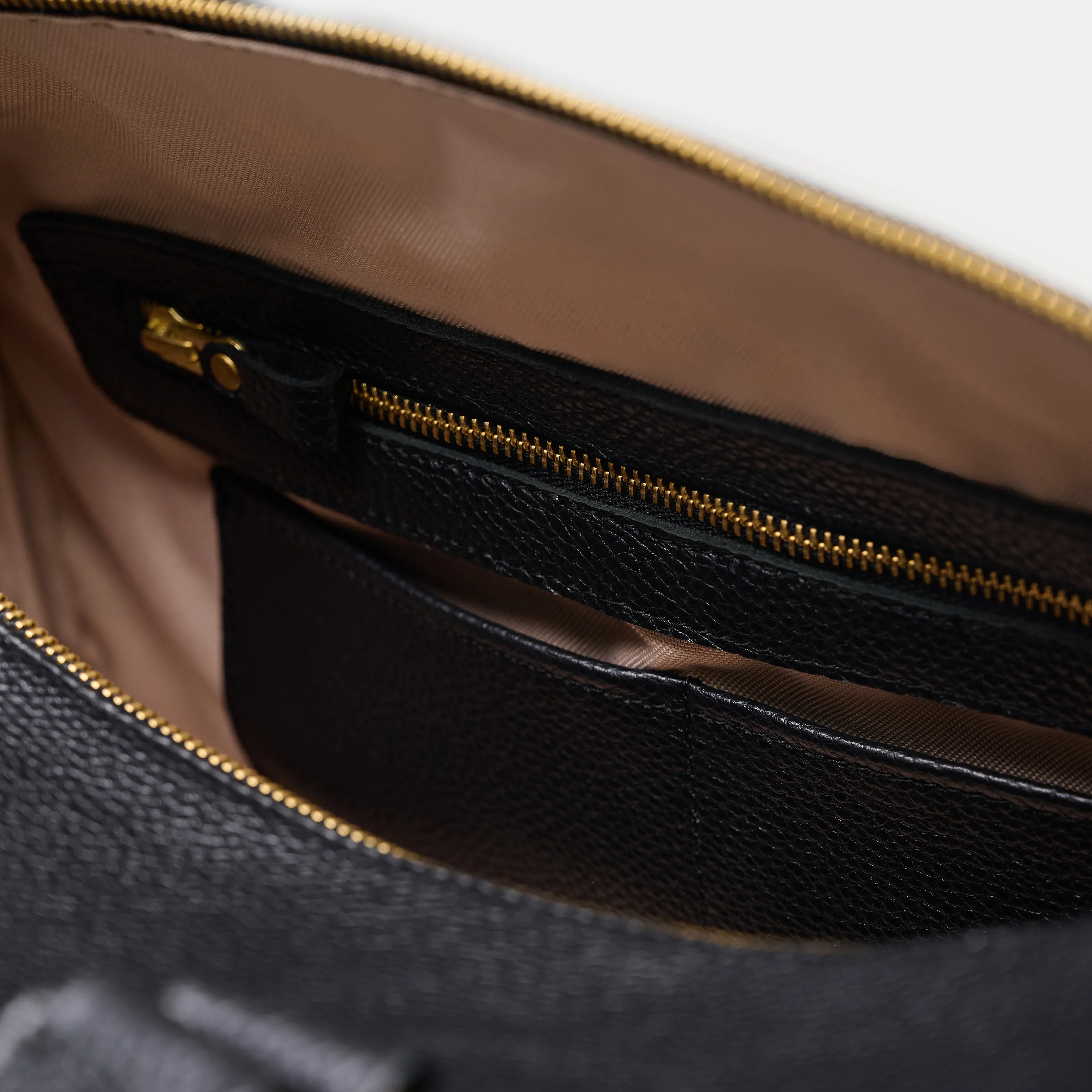 Nomad black grain leather weekend bag highlighting reinforced bottom with metal feet